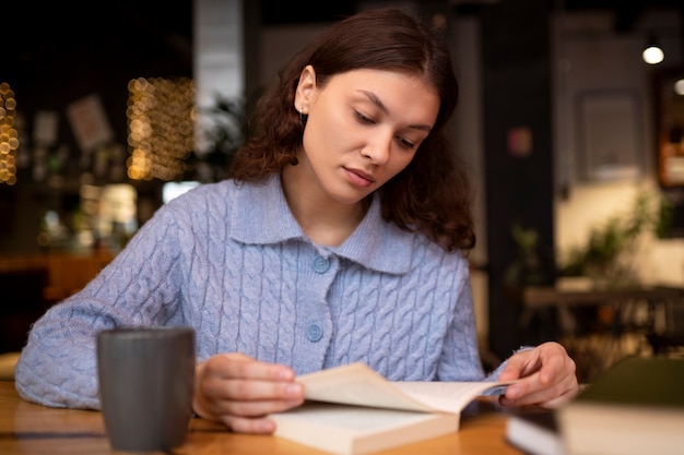 Kostenloses Foto person, die ein buch in einem café liest