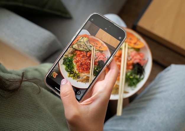 Person, die ein Meeresfrüchtegericht mit Lachs fotografiert