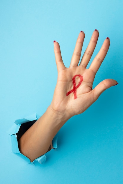 Person, die ein rotes Symbol für den Welt-Aids-Tag hält