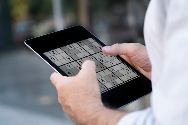 Person, die ein Sudoku-Spiel auf einem Tablet spielt