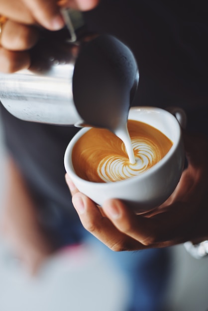 Person, die eine Tasse Kaffee serviert