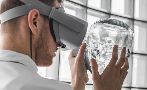 Person, die eine Virtual-Reality-Brille trägt, die eine transparente Schaufensterpuppe hält
