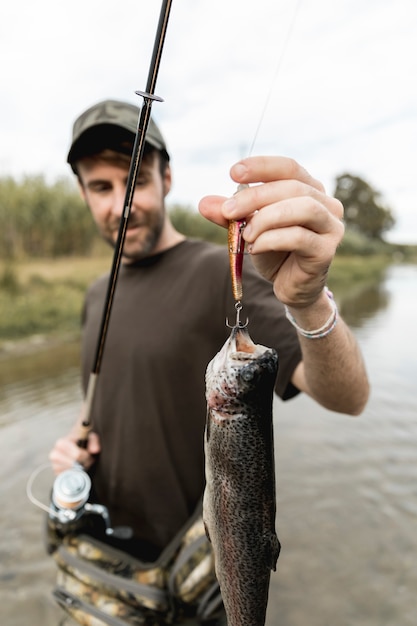 Person, die einen Fisch mit einer Stange fischt