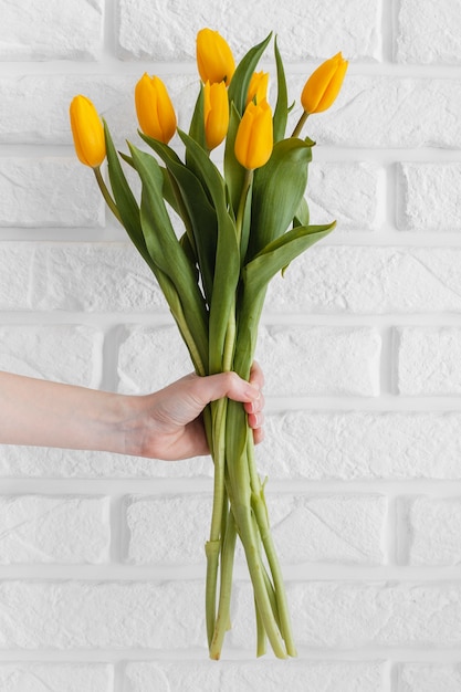 Kostenloses Foto person, die einen strauß tulpen hält