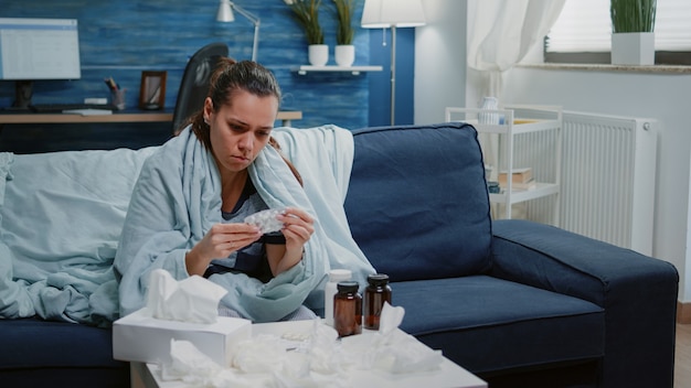 Person, die Etiketten von Kapseltabletten und Flasche mit Pillen liest