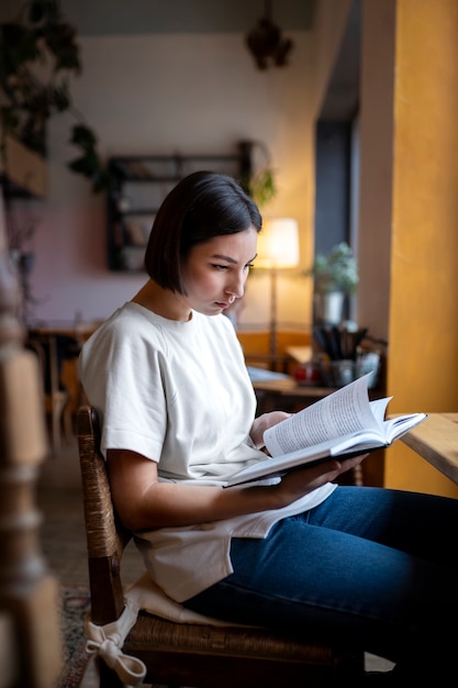 Kostenloses Foto person, die gerne ein buch in einem café liest