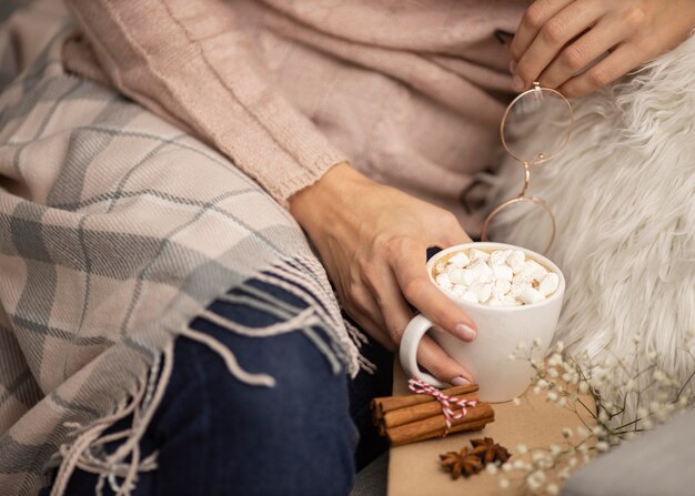 Person, die Gläser und Tasse heißen Kakao mit Marshmallows hält