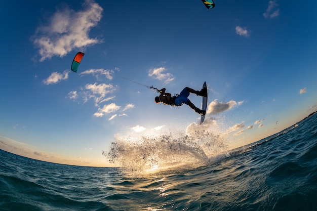 Person, die gleichzeitig beim Kitesurfen surft und einen Fallschirm fliegt. Bonaire, Karibik