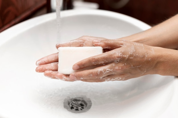 Person, die Hände mit fester Seife wäscht