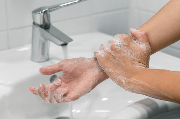Person, die Handgelenk mit Seife wäscht