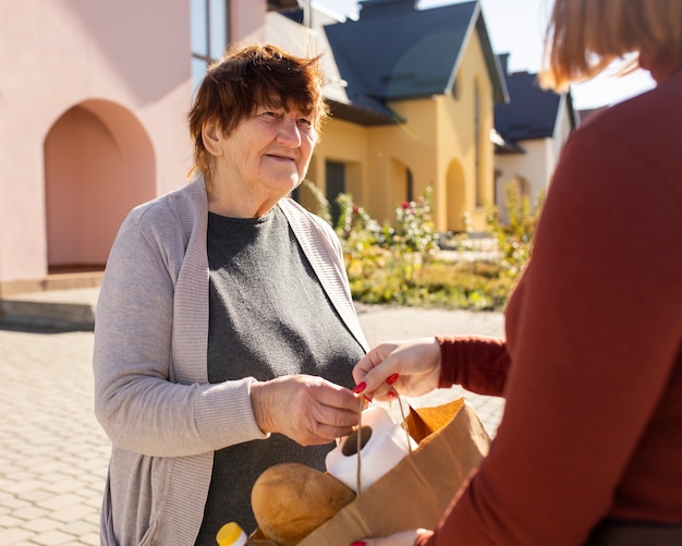 Person, die ihrem älteren Nachbarn hilft