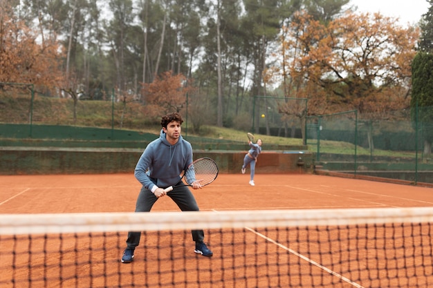 Person, die im Winter Tennis spielt