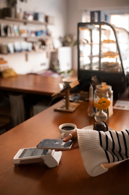 Person, die in einem Restaurant mit NFC-Technologie bezahlt