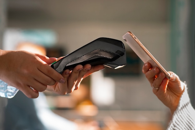 Person, die in einem Restaurant mit NFC-Technologie bezahlt