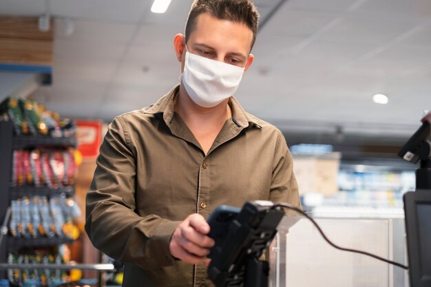 Person, die mit Gesichtsmaske einkauft