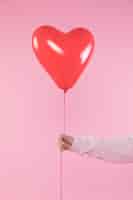 Kostenloses Foto person, die roten ballon mit thread hält