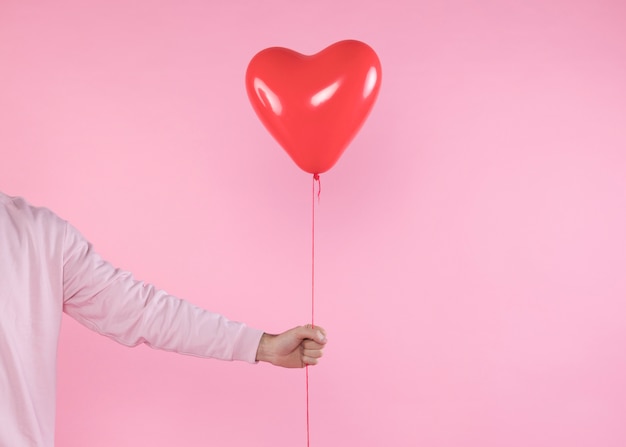 Kostenloses Foto person, die roten ballon mit torsion hält