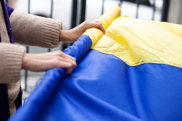 Person, die ukrainische Flagge einwickelt