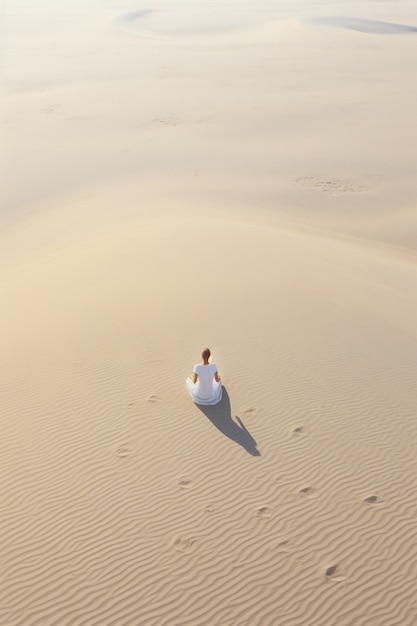 Person, die Yoga-Meditation in der Wüste praktiziert