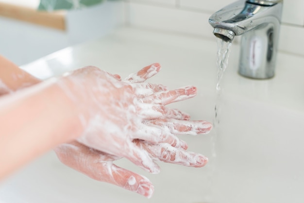 Person, die zeigt, wie man Hände mit Wasser und Seife wäscht