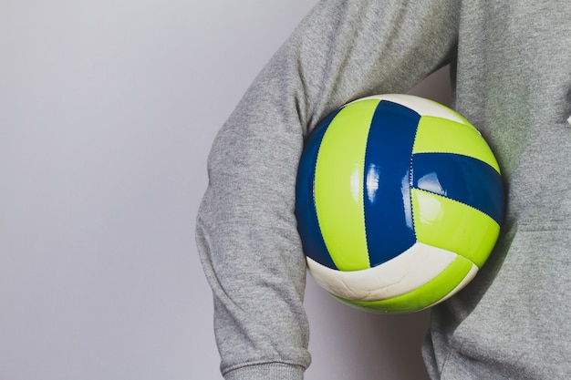 Person hält einen Ball mit dem Arm