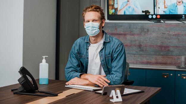 Person im Büro, die medizinische Maske trägt