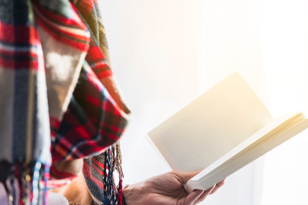 Person im Schal, der Buch hält