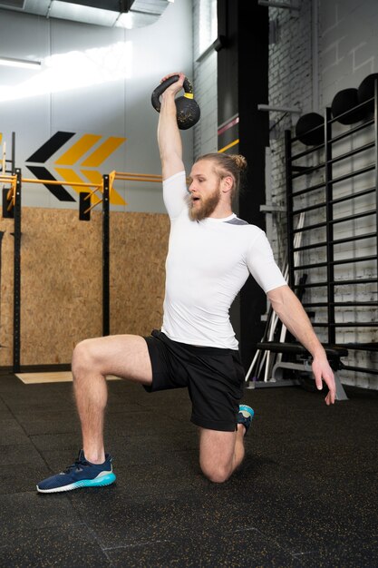 Person im Sportstudio mit Kettlebells