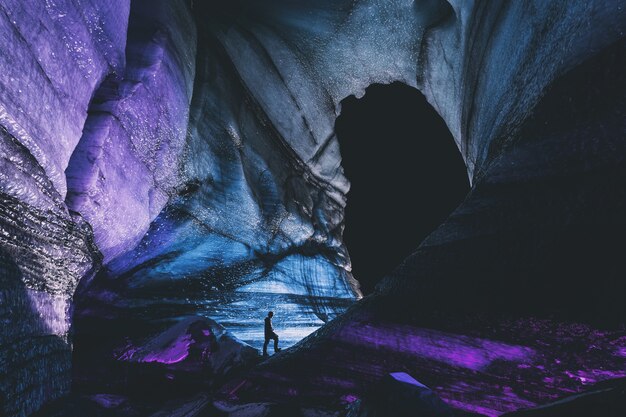 Person in der schwarzen Jacke, die auf Felsformation steht