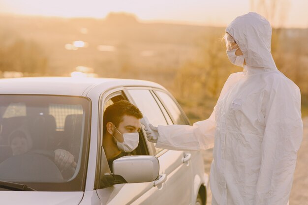 Person in einem Schutzanzug überprüft die Temperatur