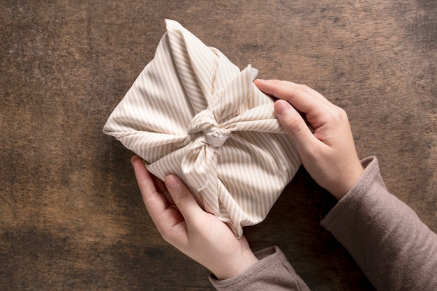 Person mit festlich verpacktem Weihnachtsgeschenk