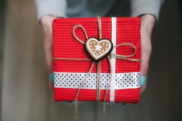 Person mit roten Geschenk mit einem goldenen Herzen mit einem Stern in der Mitte