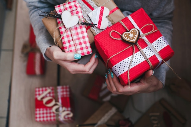 Person mit roten Geschenk mit einem goldenen Herzen mit einem Stern in der Mitte