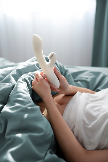 Person mit Sexspielzeug im Bett