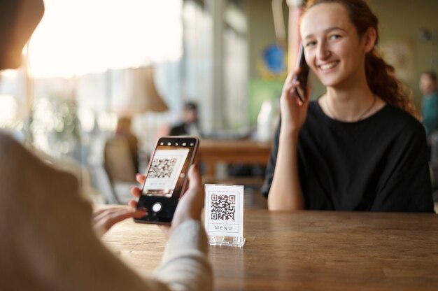 Person scannt qr-code in der cafeteria