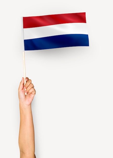 Person winkt die Flagge der Niederlande