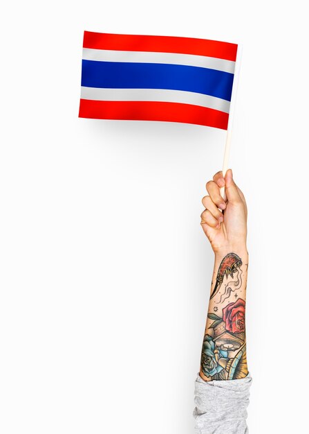 Person winkt die Flagge des Königreichs Thailand