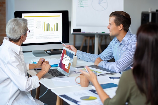 Kostenloses Foto personen, die während eines meetings ein digitales gerät verwenden