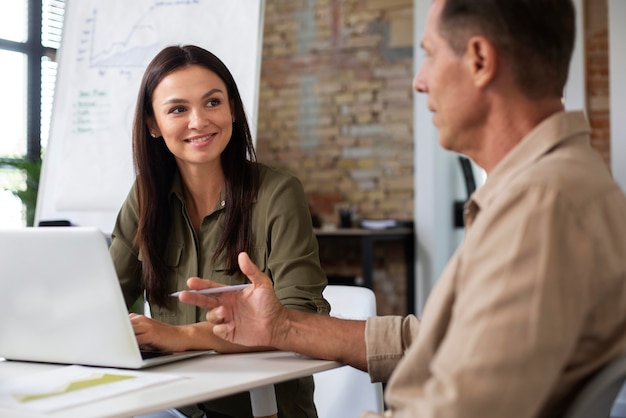 Personen, die während eines Meetings ein digitales Gerät verwenden