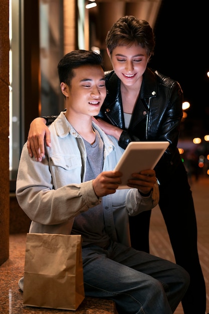 Kostenloses Foto personen mit mittlerer aufnahme, die auf das tablet schauen