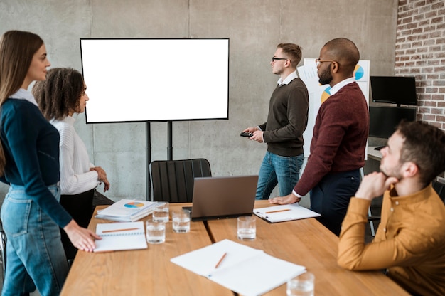 Kostenloses Foto personen während eines meetings mit einer präsentation