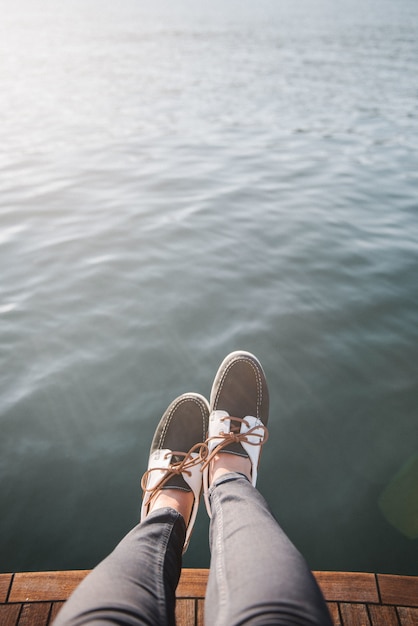 Kostenloses Foto personenfüße auf dem boot, das tagsüber auf dem meer segelt