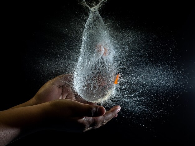 Personenhände und Wasser, das über sie spritzt