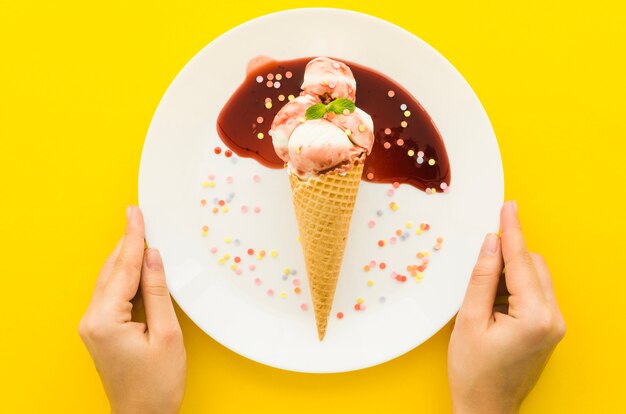 Personenhalteplatte mit Eiscreme im Waffelkegel