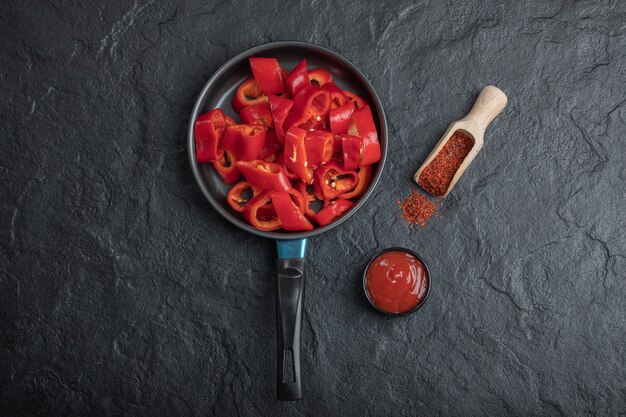 Pfanne aus geschnittenen roten Paprika mit gemahlenem Pfeffer und Ketchup