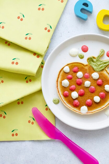 Pfannkuchen-Frühstücksleckerbissen für Kinder in Form einer lustigen Erdbeere