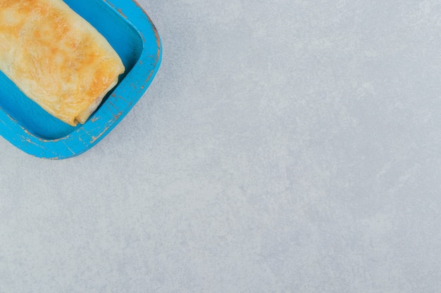 Pfannkuchen gefüllt mit Fleisch auf blauem Teller.