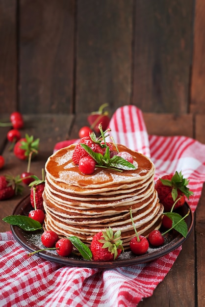 Kostenloses Foto pfannkuchen mit beeren und sirup im rustikalen stil