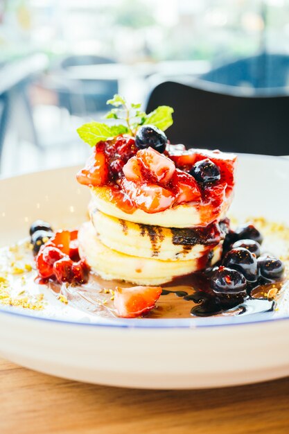 Pfannkuchen mit gemischten Beerenfrüchten im weißen Teller