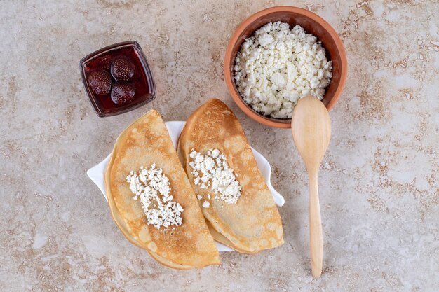 Pfannkuchen mit Quark und Erdbeermarmelade rollen